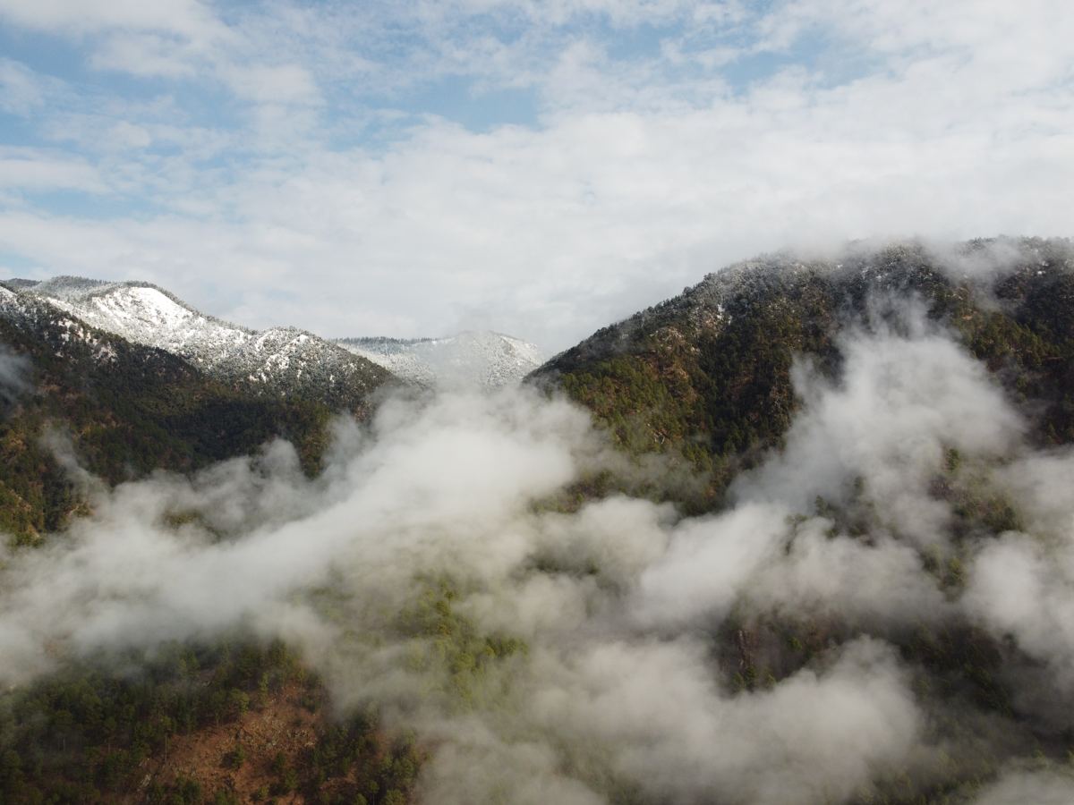 Mist rolling over snow-dusted mountain peaks